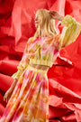 A pleated full skirt in a colorful print with a matching long sleeve top