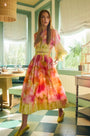 A pleated full skirt in a colorful print with a matching long sleeve top