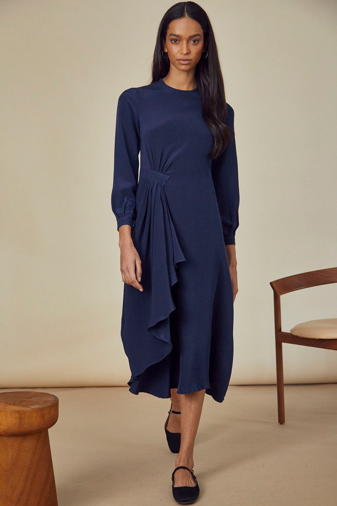 The Lawton Dress is a long sleeve midi dress has ruffle detailing at the waist and a round neckline.