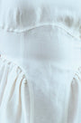 Close up of white linen mini dress with structured bustier bodice.