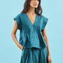 A cropped, boxy top, v-neckline, delicate pintuck detailing and short banded sleeve in petrol green.