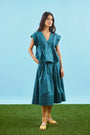 Petrol green pleated maxi skirt with side-seam zipper, fixed waistband, and functional pockets.