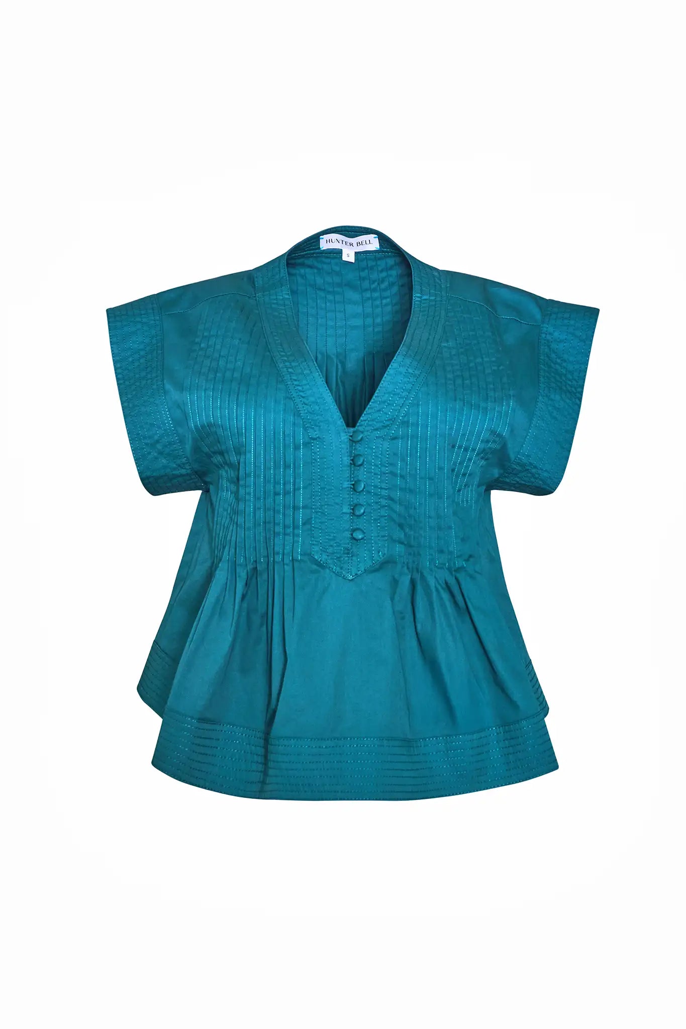 A cropped, boxy top, v-neckline, delicate pintuck detailing and short banded sleeve in petrol green.