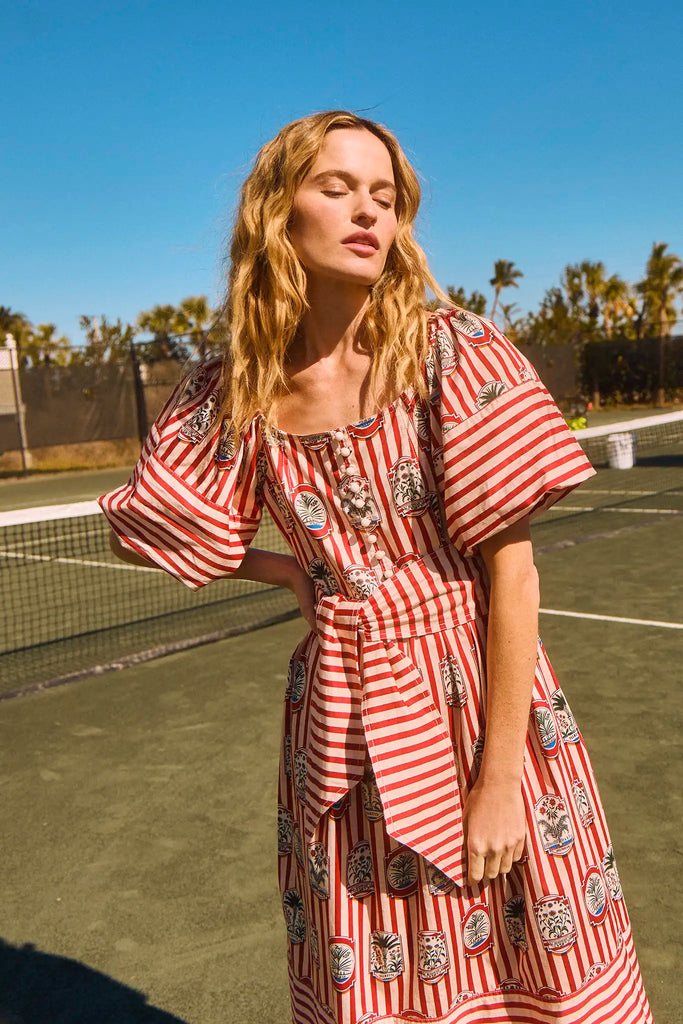 The Lucy midi dress has a square scoop neck, puff sleeves, front button placket, and a self belt.