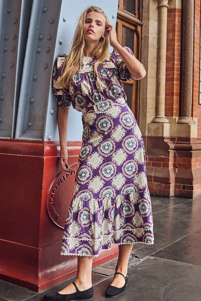 The Emilia tie dye midi skirt in purple London rain features a banded waist with eyelet trim.