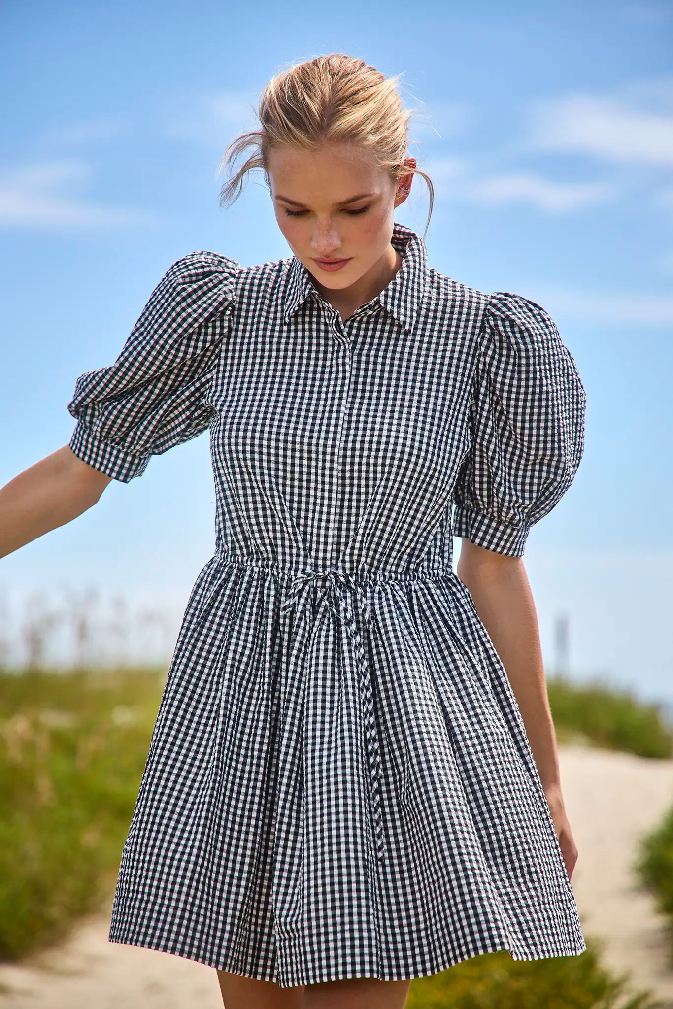 The McCauley Dress in Black and White Gingham on model at beach 