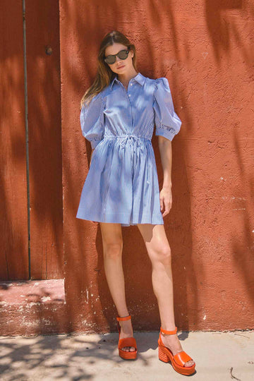 The McCauley Dress has a pointed collared, puff sleeves, on-seam hip pockets and a drawstring waist.