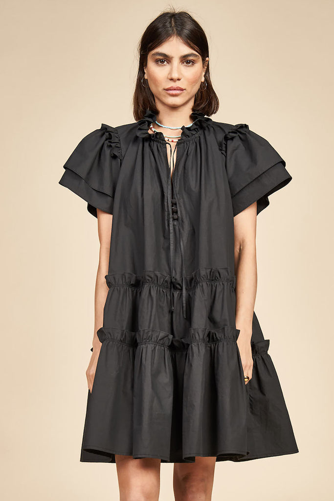 Merritt is a short sleeve swing dress with ruffle detailing along the v-neck and tiered bodice.

