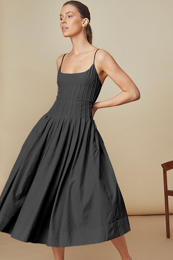The Naomi Dress has thin spaghetti straps, a scoop neckline, and pintuck detailing on the bodice.