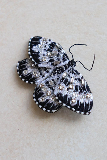 This handmade butterfly brooch has metallic thread embroidery, crystals, and seed beads.