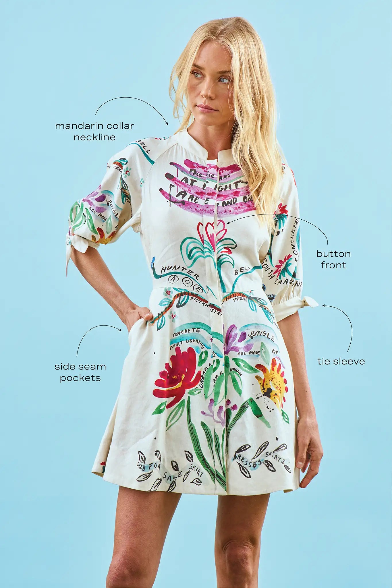 A mini dress with colorful print, front-buttons, mandarin collar, and elbow length sleeves with ties.