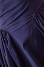 A sleeveless midi navy dress with a fitted bustier bodice, crew neckline, and a bustled full skirt.