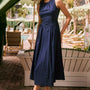 A sleeveless midi navy dress with a fitted bustier bodice, crew neckline, and a bustled full skirt.