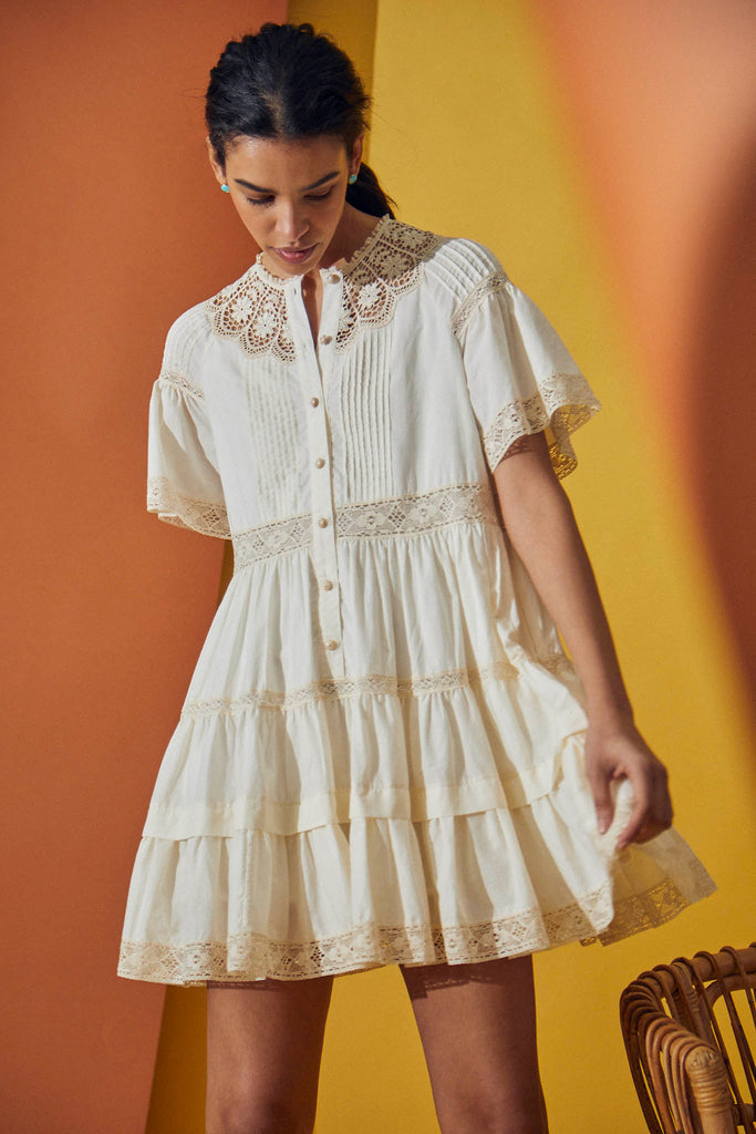 The Newton mini dress has a lace trim crew neck, scalloped lace yoke, and raglan flutter sleeves.