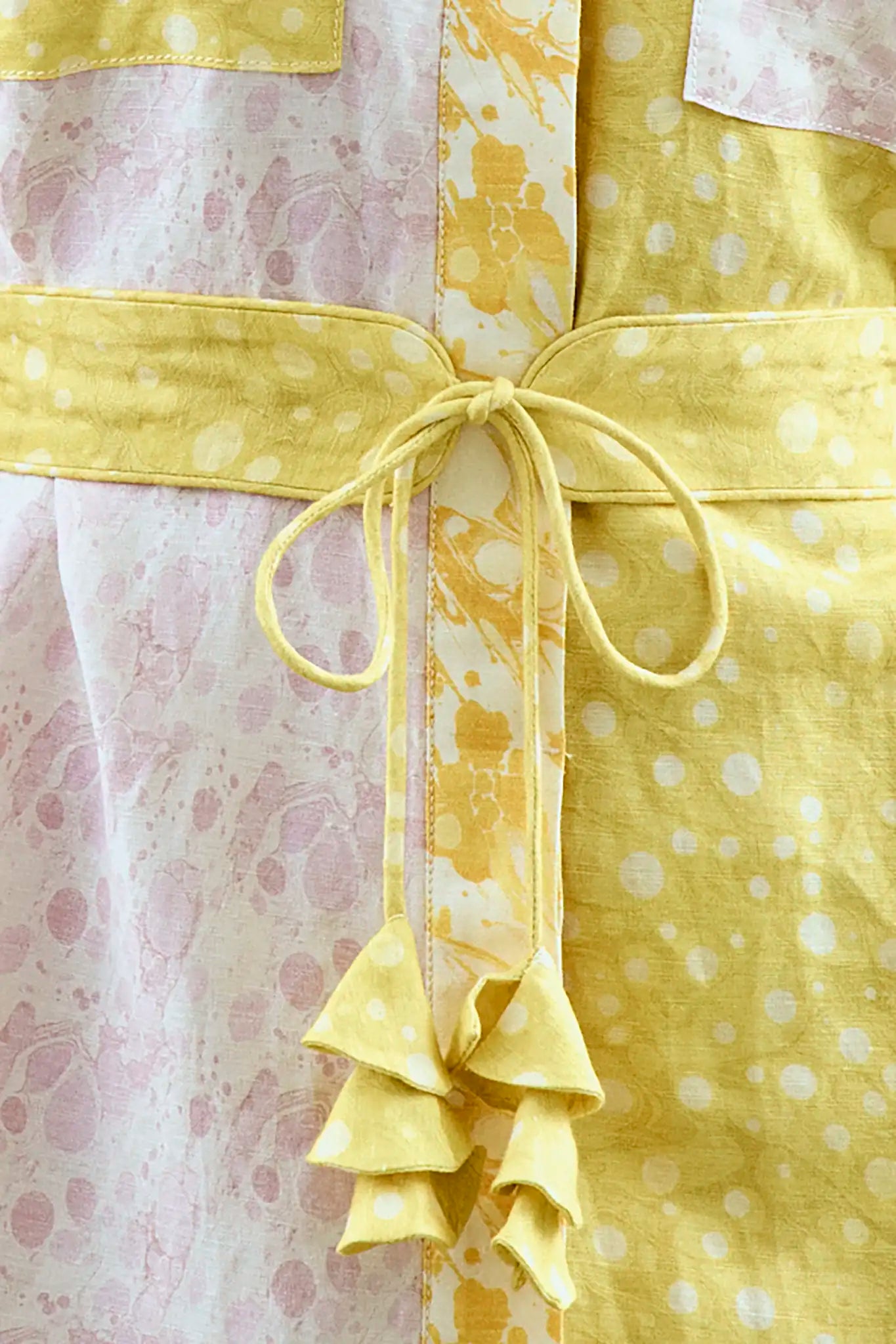 Close up of the Nicole Dress in Marble Mix with self-tie belt and fabric bell ends.