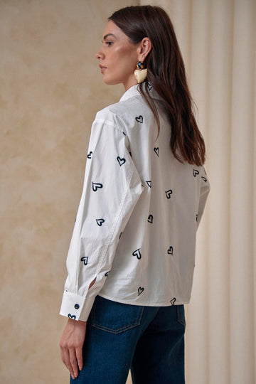 A shirt collar neck with front button placket, drop shoulders and long sleeves with button cuffs.