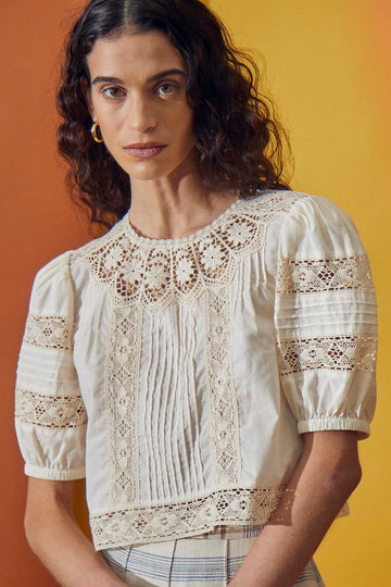 The Ouisie top has a crew neckline with baby lace trim, a scalloped lace yoke, and puff sleeves.