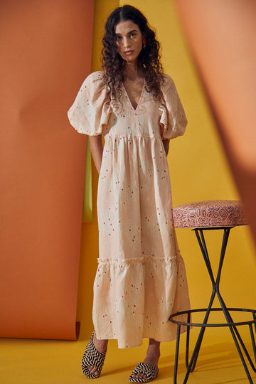 The Palmer dress features elbow-length puff sleeves, fitted shoulders and bust, and a flounce hem.