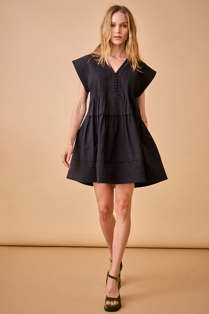 The Parker dress has a v-neckline, front placket, banded cap sleeves, and a pleated yoke.