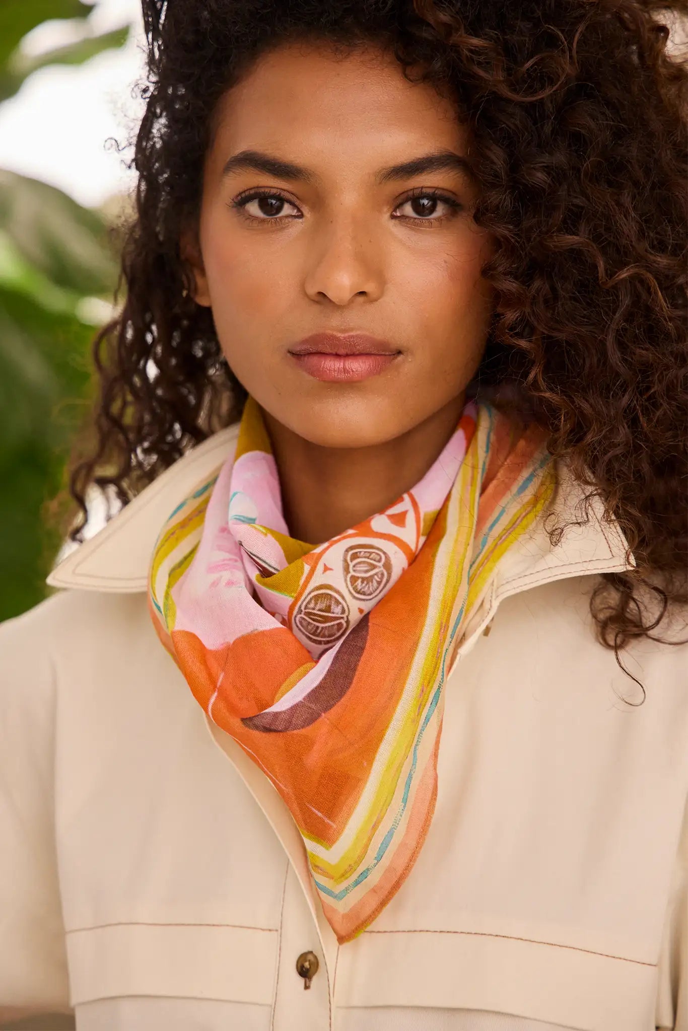 a woman with curly hair wearing a scarf