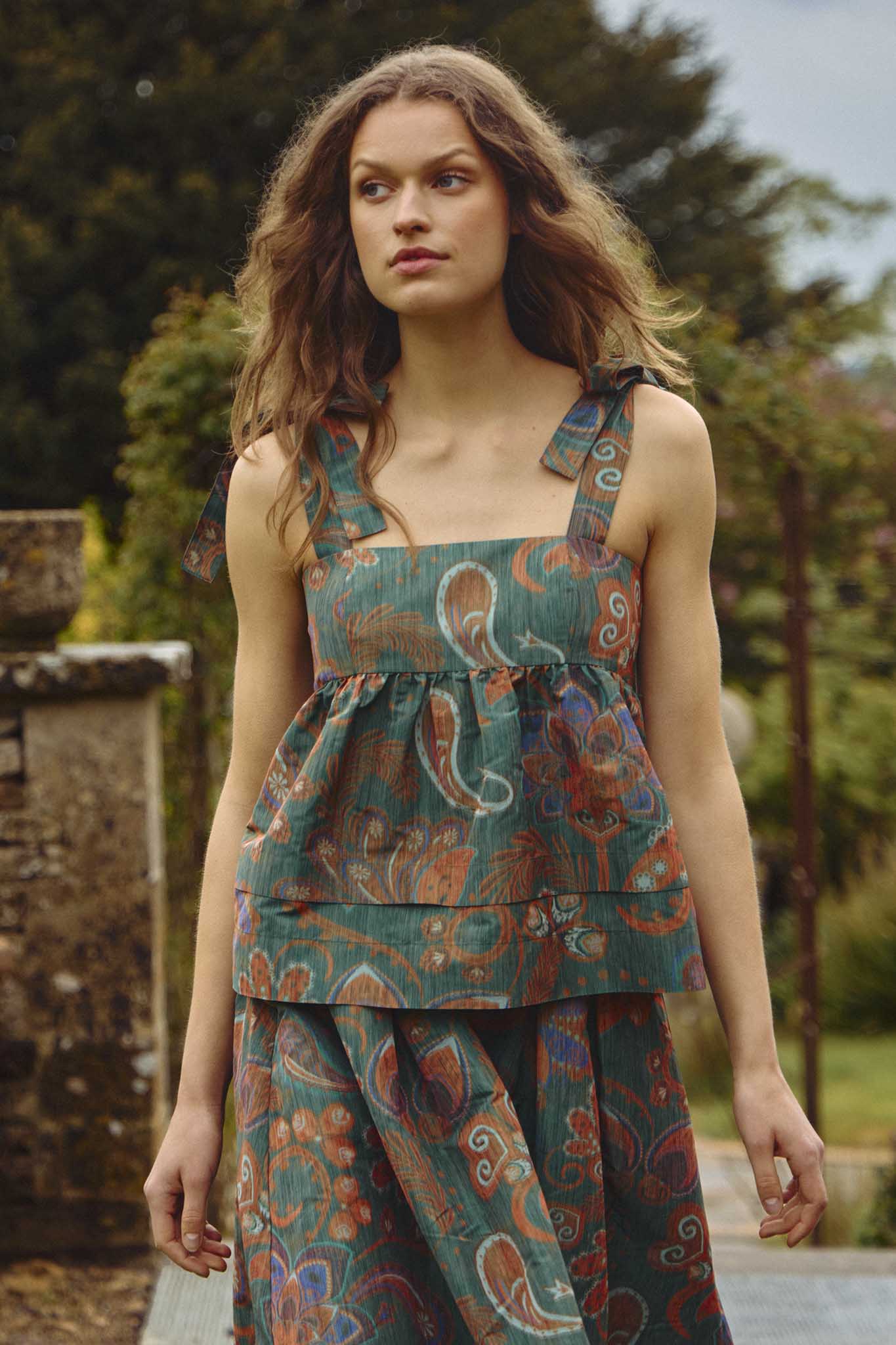 The Pruett Top has self-tie straps and an empire waist that pleats and flares with tiered panels.