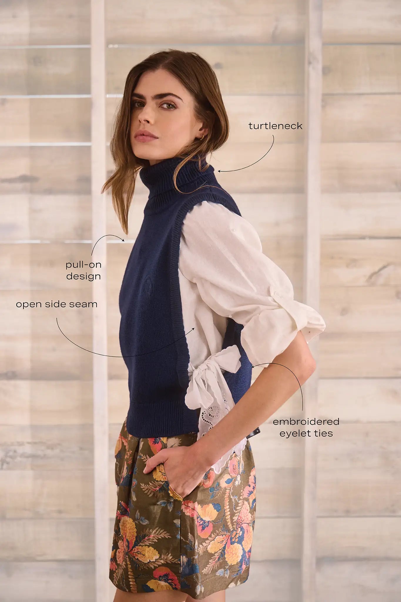 Navy wool blend turtleneck with an open side seam with embroidered eyelet ties.