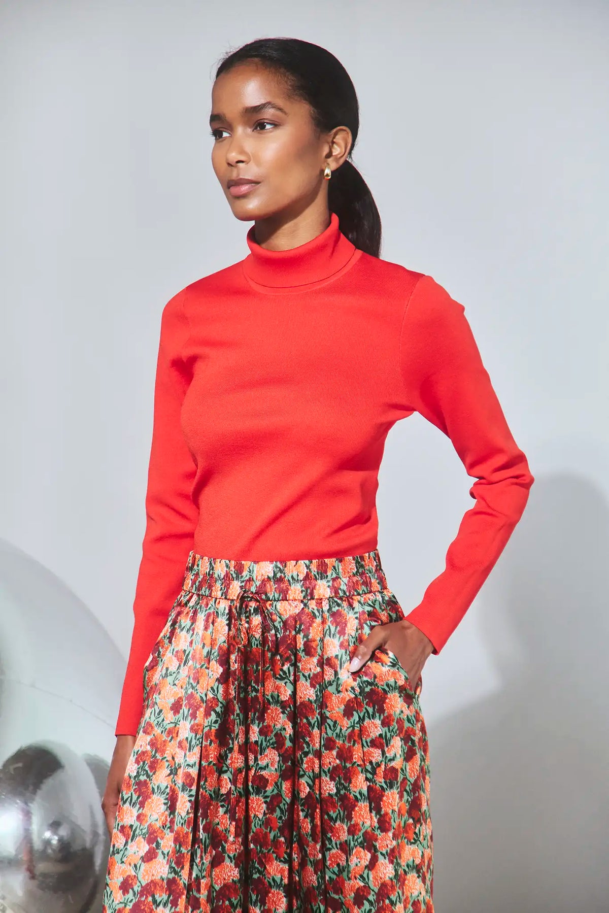 The Roen Turtleneck in Crimson Red paired with the Whisper Pant in Crimson Blossom.
