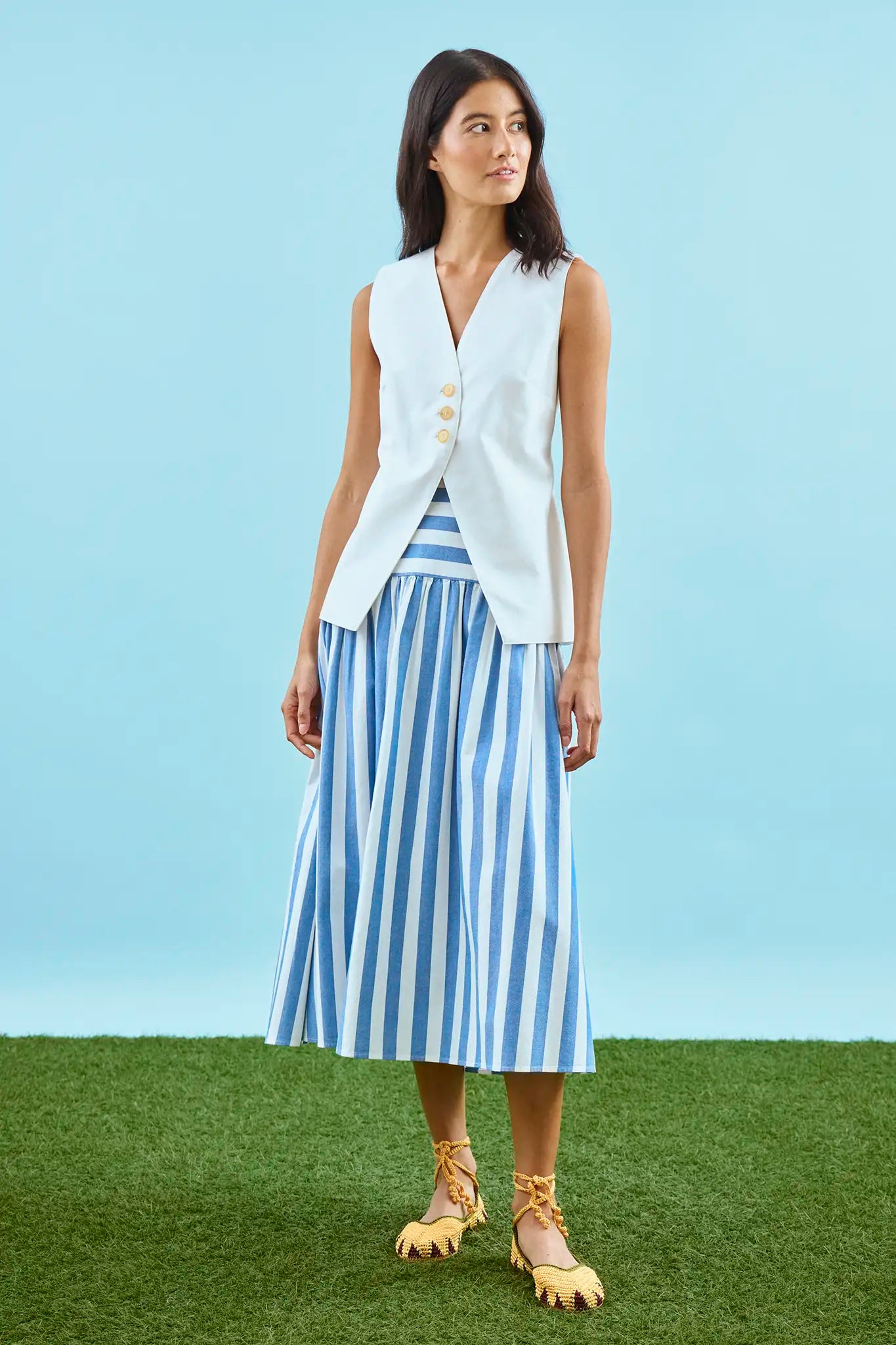 The Alyssa Midi Skirt paired with Roma Vest in blue and white stripe on a model.