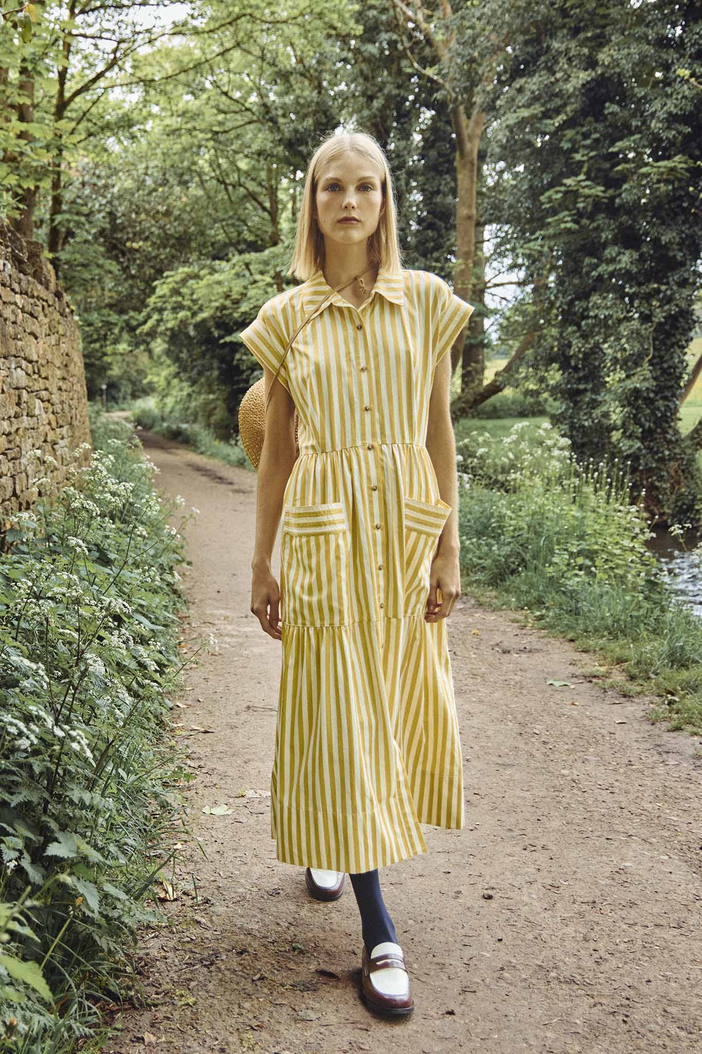 This Sarah dress is a shirt dress with banded cap sleeves, a tiered skirt, and patch front pockets.