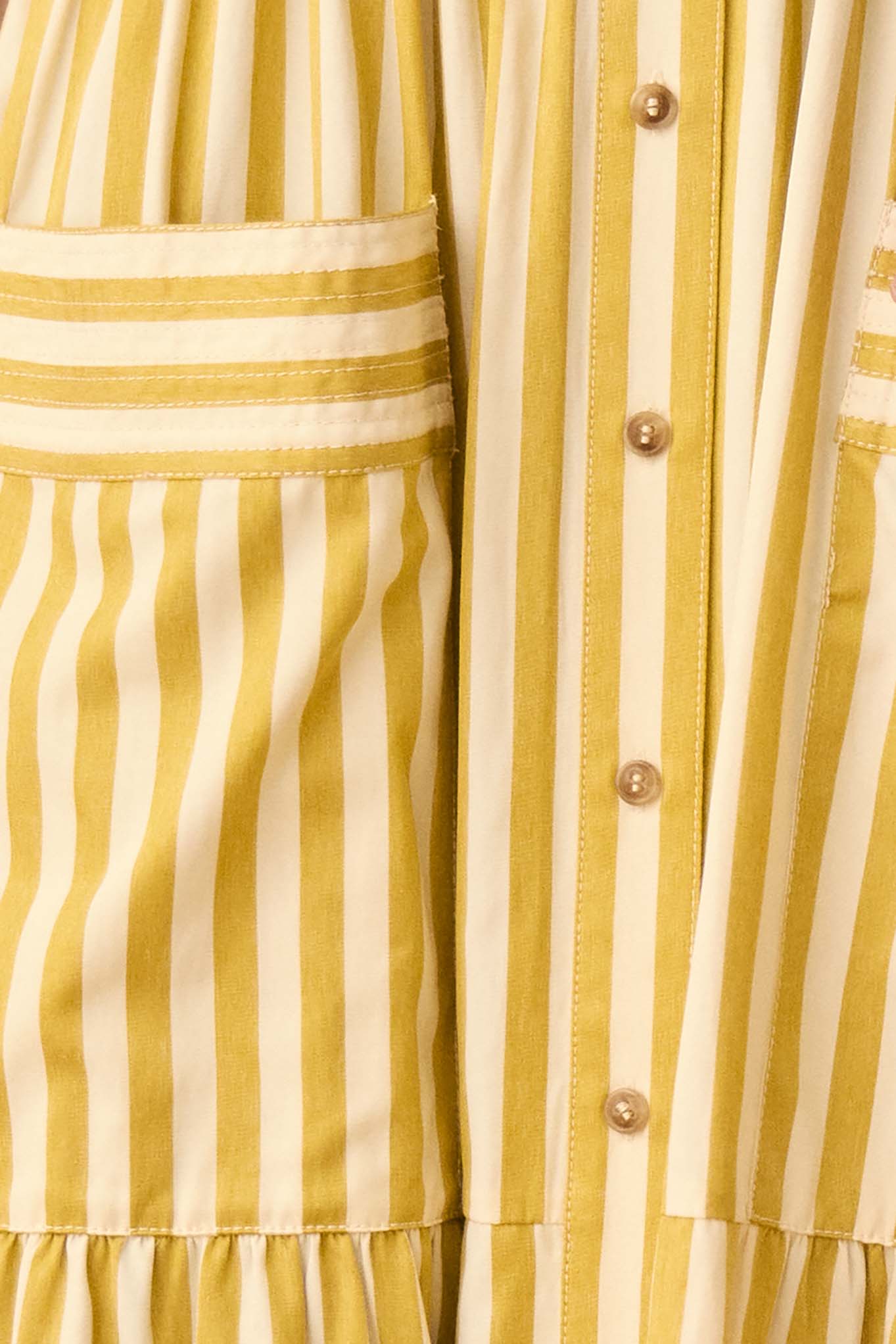 This Sarah dress is a shirt dress with banded cap sleeves, a tiered skirt, and patch front pockets.