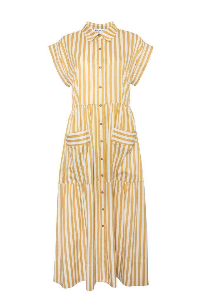 This Sarah dress is a shirt dress with banded cap sleeves, a tiered skirt, and patch front pockets.