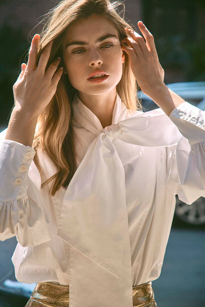 The Shay Blouse has a tie-front neckline and long, full sleeves adorned with angled button cuffs.