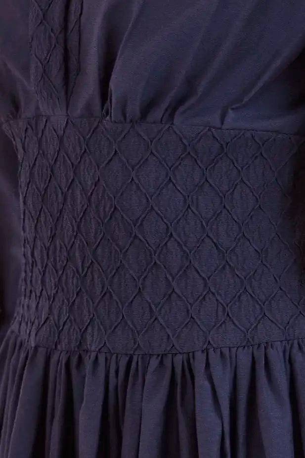 Navy diamond-smocked novelty shirting fabric with a soft V effect and blouson sleeves.