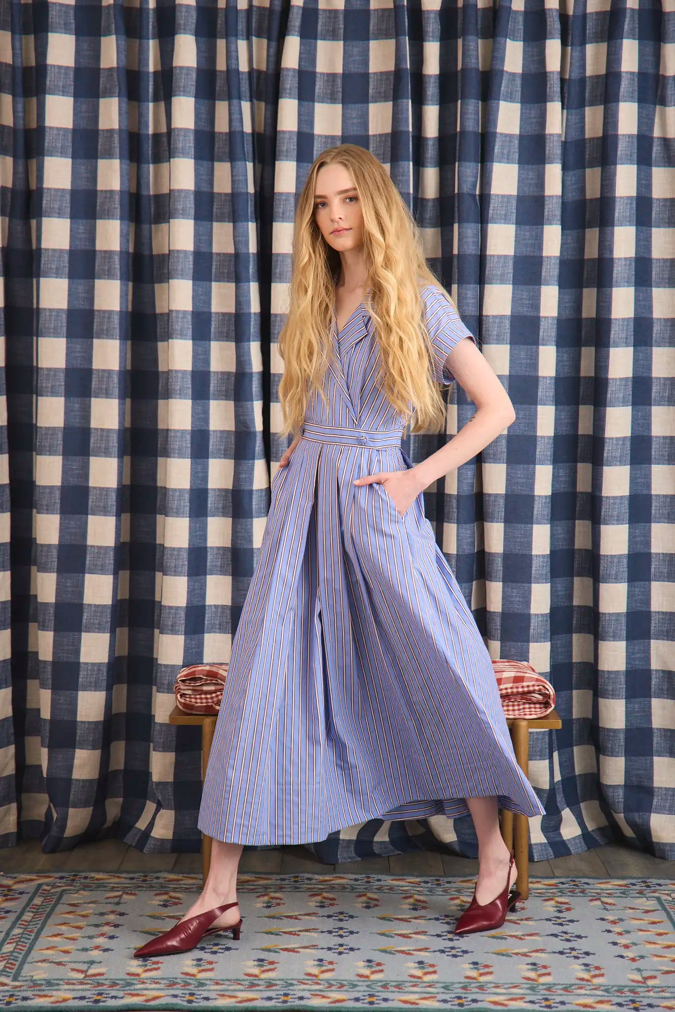 The Sloane Dress has a V-neckline, short banded sleeves, a fitted waist, and full midi-length skirt.