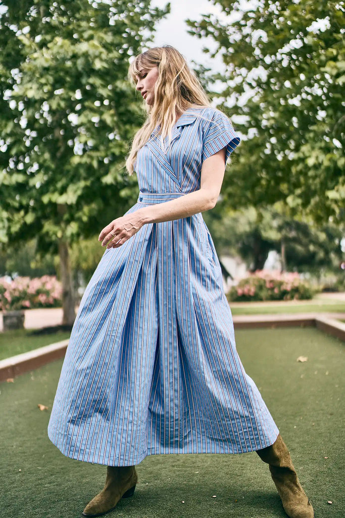 The Sloane Dress has a V-neckline, short banded sleeves, a fitted waist, and full midi-length skirt.