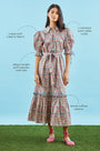 An open V-neckline with a ruffled collar, elbow length puff sleeves with tie details.