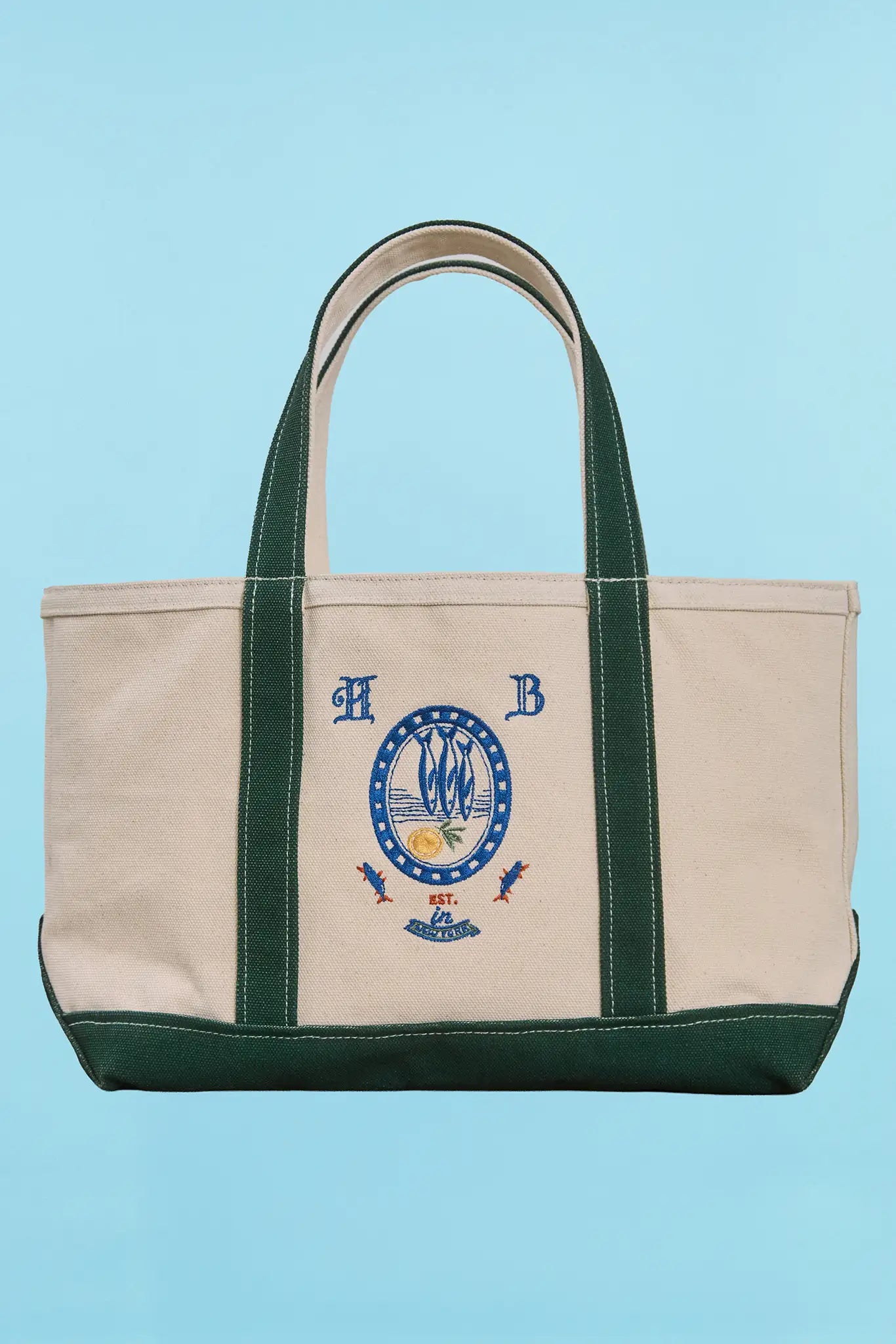 The medium canvas tote bag with green handles and fish motifs