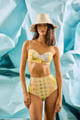 Bikini Top & Bikini Bottom in Still Life Symphony modeled in front of blue wall.