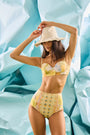 Bikini Top & Bikini Bottom in Still Life Symphony modeled in front of blue wall.