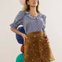 The Valene Blouse in Checkmate Navy paired with the Dottie Mini Skirt in Saddle. 