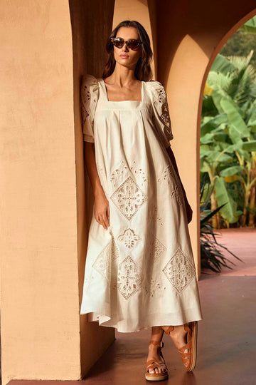 The Waverly dress has a square neckline, elbow-length sleeves, eyelet details and pleat accents.