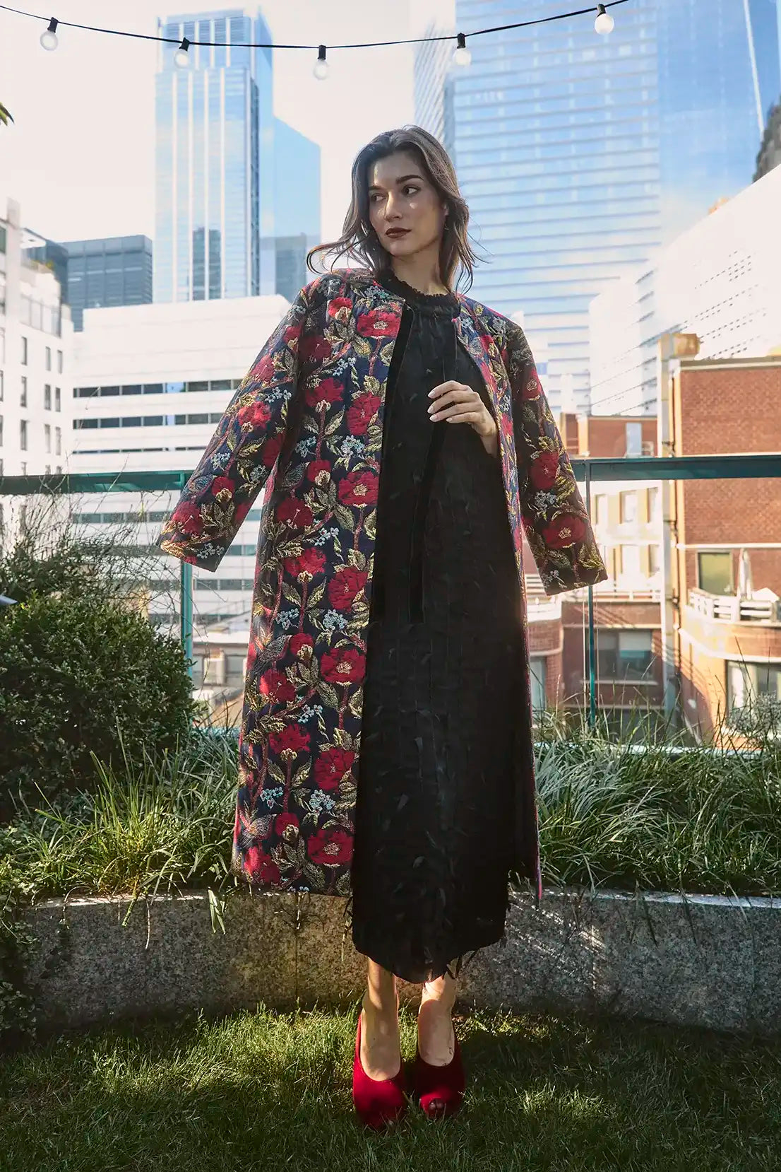The Whitney Dress in Manhattan Chiffon Onyx paired with the Portman Coat in Palais Floral Gold.