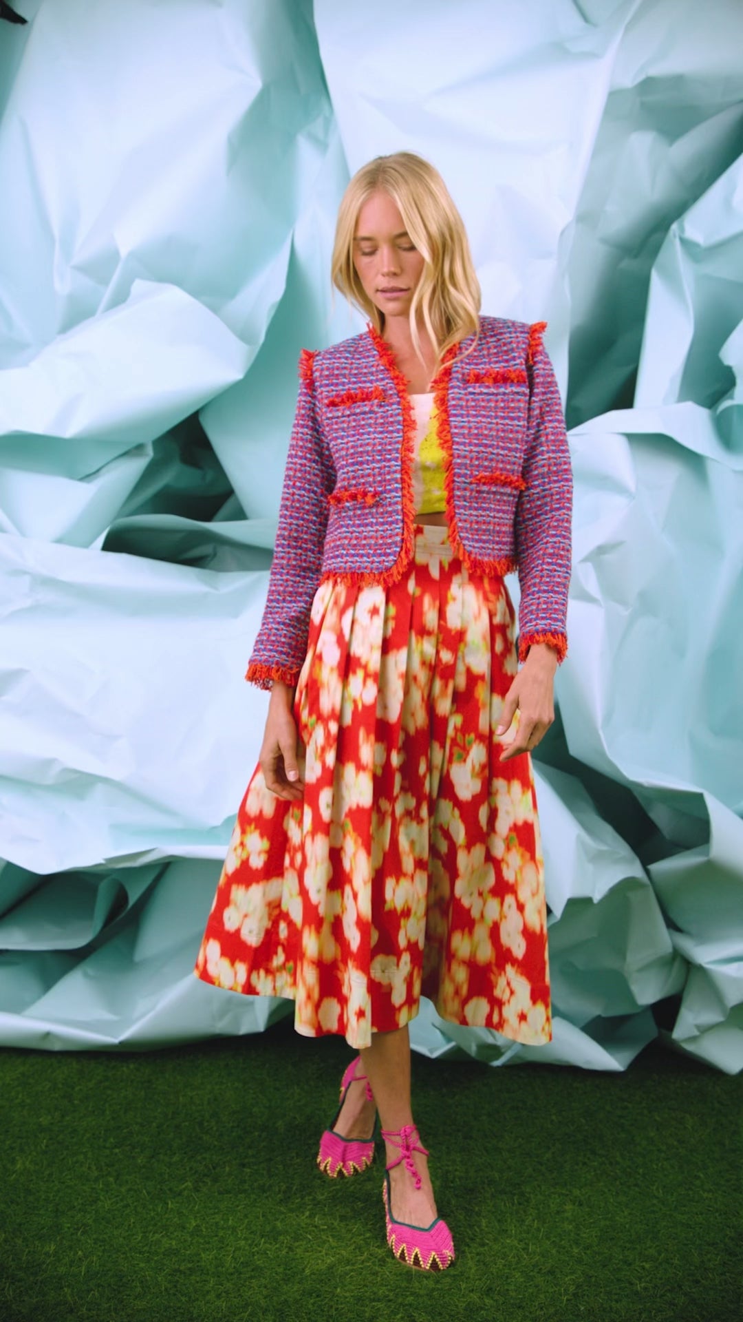 A full-length pleated orange and yellow printed skirt with a fixed waistband and functional pockets.