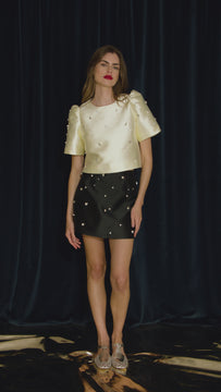 The Britt Skirt is a duchess satin black mini, hand embroidered with pearl and rhinestone detailing.