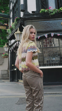 The Navadine is a pull-over crop sweater with a collared neckline and short sleeves.