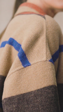 A sophisticated midi length camel coat with a notched collar, drop shoulders and an open placket.