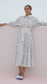 An embroidered shirt dress with a fitted yoke at the waist, a pleated skirt and an optional belt.