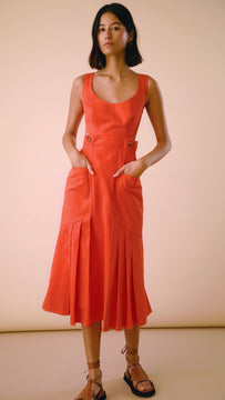The Giselle Dress has a scoop neckline, a side cut-out, pleated flounce hem and oversized pockets.