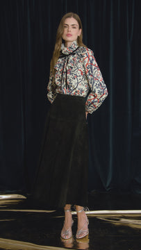 The Eloise Blouse is framed by a pleated yoke, a high ruffled collar, and tied with velvet ribbon. 