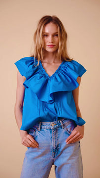 A sleeveless tank with a ruffled v neck, featuring pintucks at the bodice and a boxy, relaxed fit.